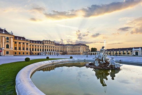 Schönbrunn Palace in Vienna at sunset with reflecting fountain and baroque architecture