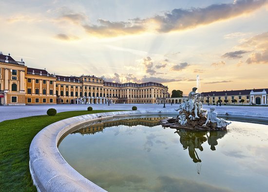 Schönbrunn Palace in Vienna at sunset with reflecting fountain and baroque architecture